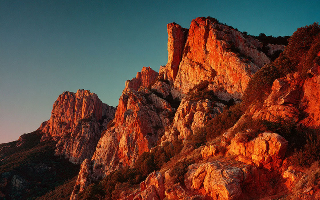 Falaises ocre au soleil couchant, saturation dramatique Fuji Velvia 50, image Midjourney