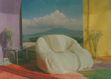 Fauteuil clair devant décor coloré, lumière naturelle, ambiance onirique.