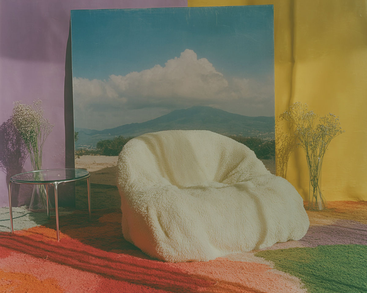 Fauteuil clair devant décor coloré, lumière naturelle, ambiance onirique.